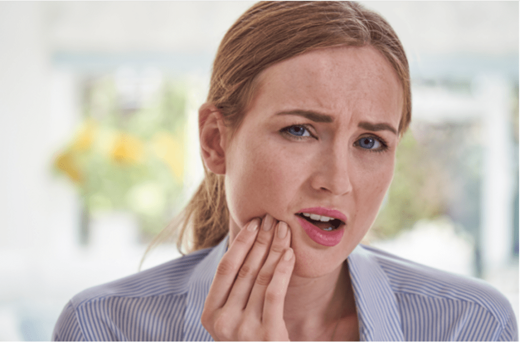 Mulher com dor na face em Alphaville, representando os sintomas de DTM e dor orofacial, buscando tratamento especializado e sem cirurgia.