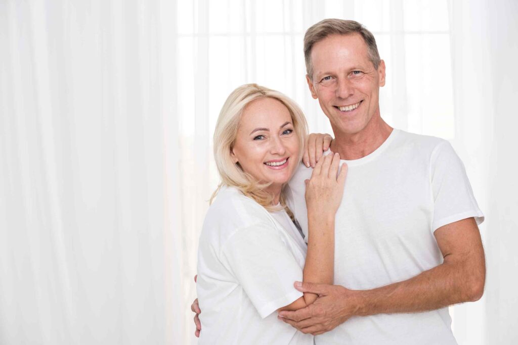 Foto de um casal de idosos sorrindo, representando a felicidade e a confiança restauradas com implantes dentários realizados com tecnologia avançada na Clínica Armonì, em Alphaville.